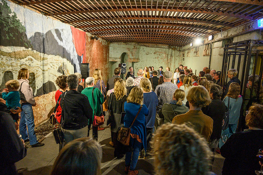 Audience watching contemporary art performance event in historic renovated building in Newcastle.